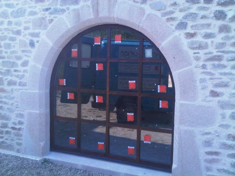 Façade dissimulant une porte double battant, dormant en arc en plein cintre